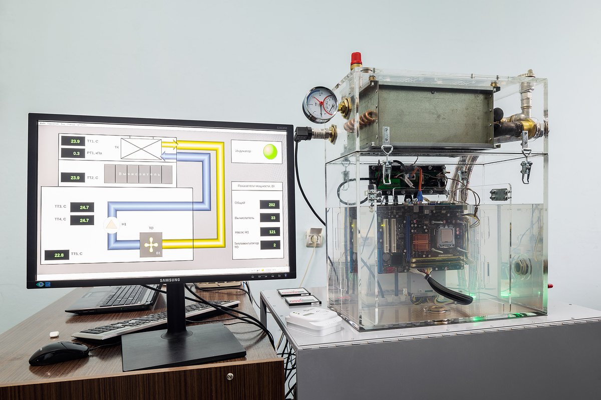 Слева монитор управляющей системы, справа компьютер, на его процессоре заметно кипение.